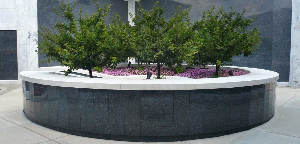 A circular columbarium wall, with an entry point to the empty space in its center, commands a courtyard space.
